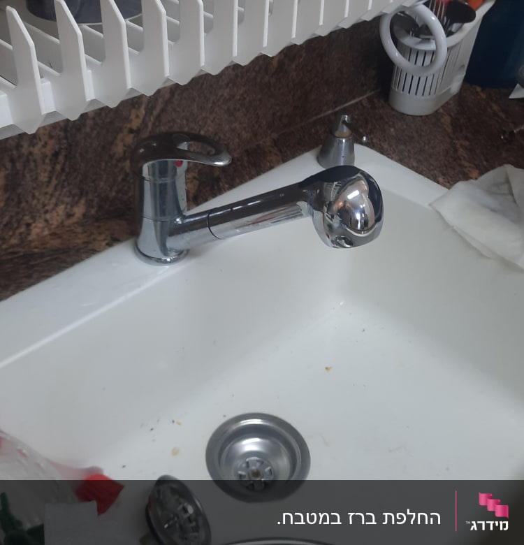 ברז מטבח עם חלקים מפורקים בכיור